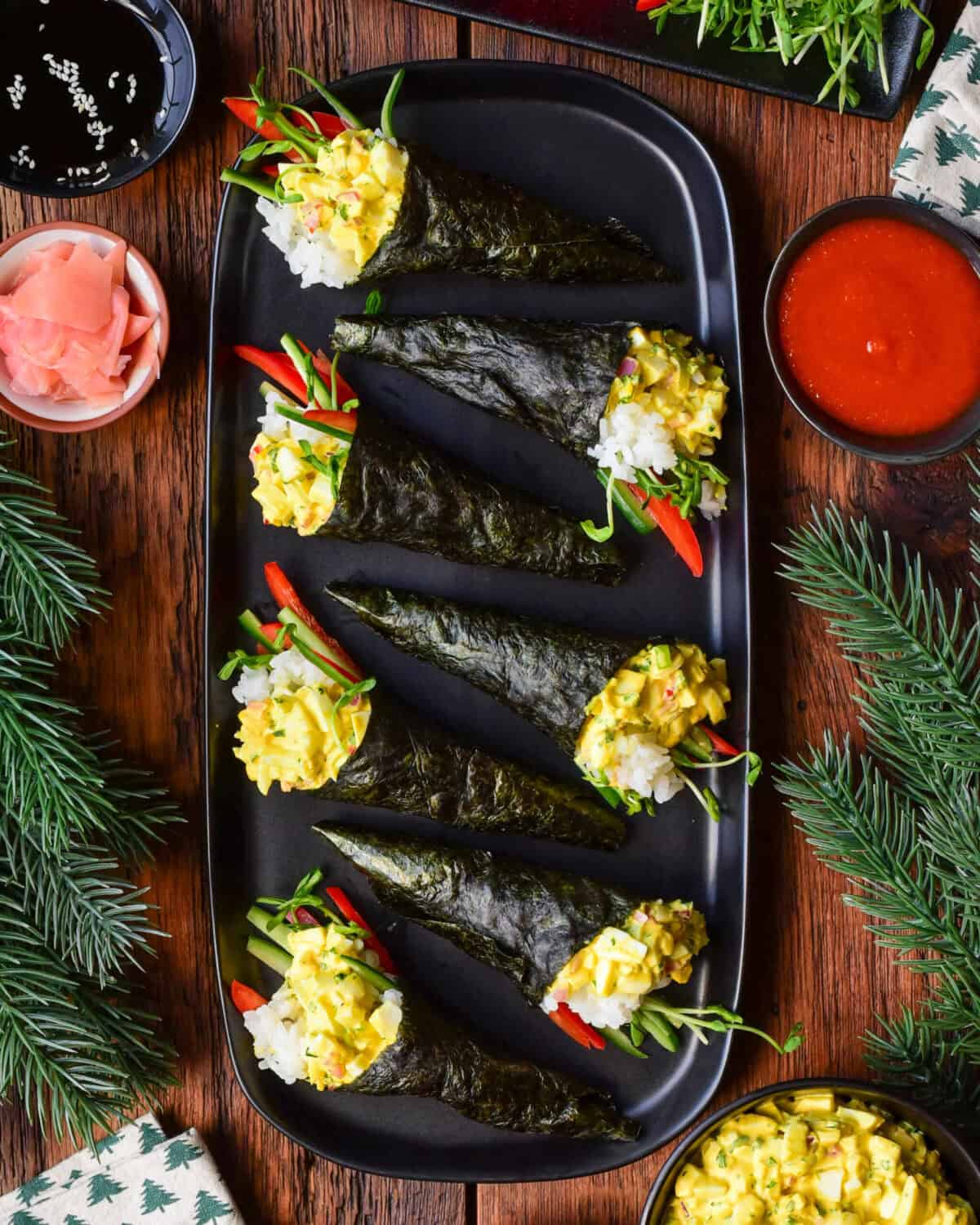 Seven Egg Salad Temaki Rolls on a platter in a festive setting.