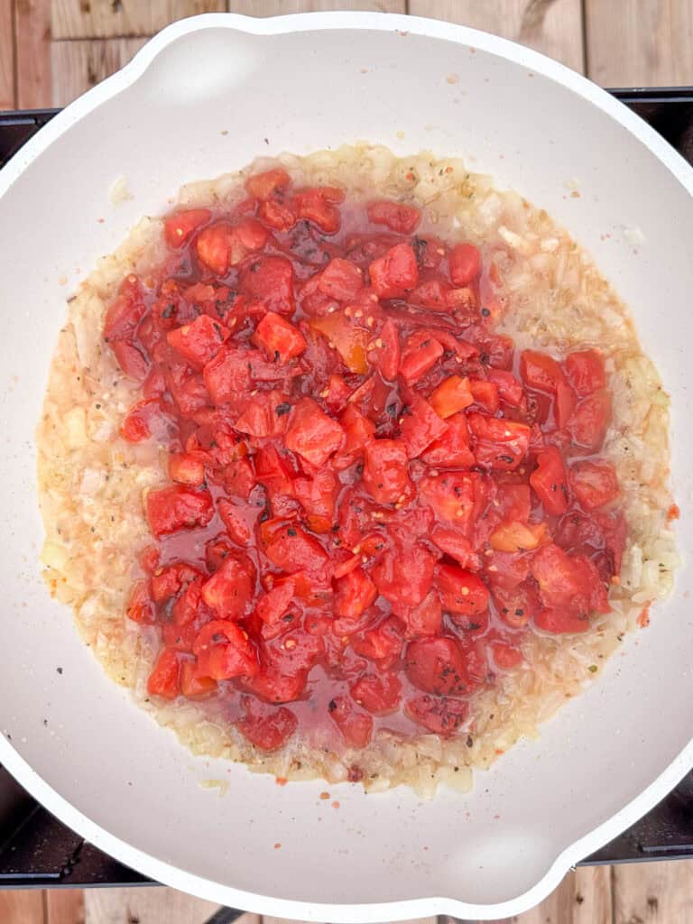 Add the crushed tomatoes to the onions and garlic.