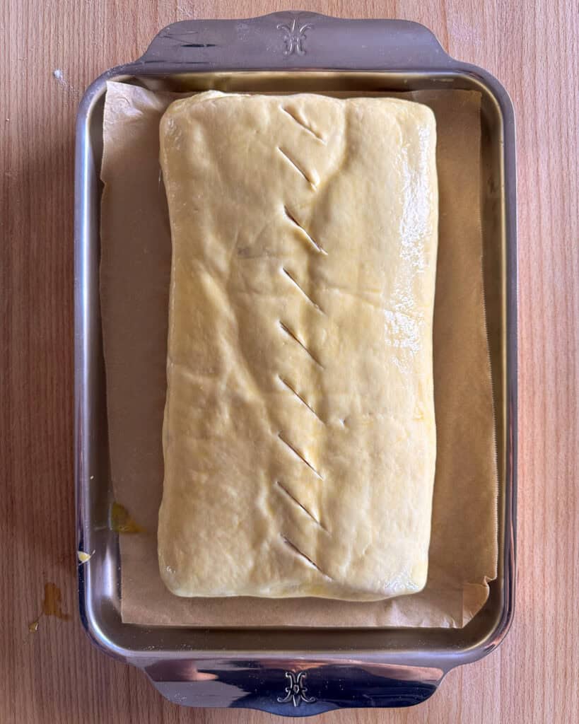 Brush the entire surface with egg wash and make slits for vents.