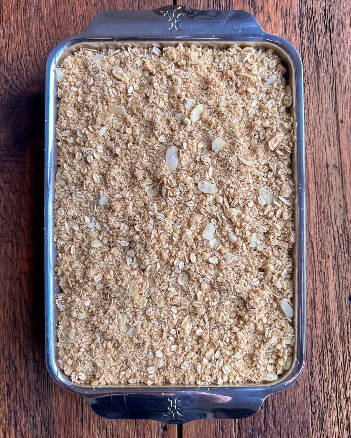 Crumble topping sprinkled over the baked fruit crisp.