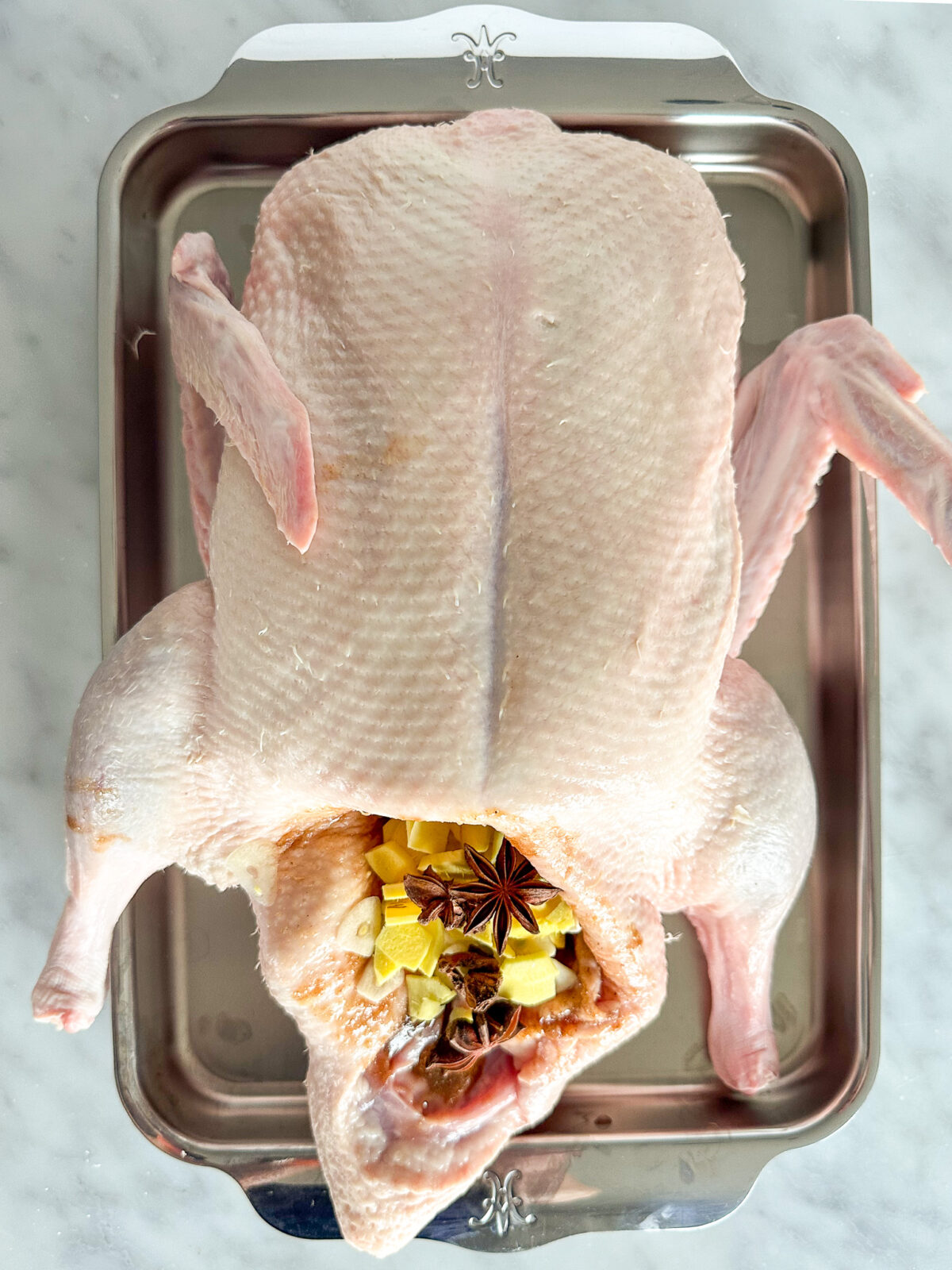 Stuff the duck cavity with chopped ginger, garlic, and star anise.