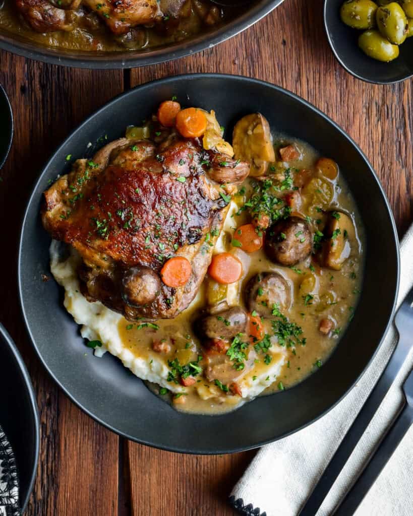 A braised turkey thigh on a bed of mashed potatoes with a rose wine sauce.
