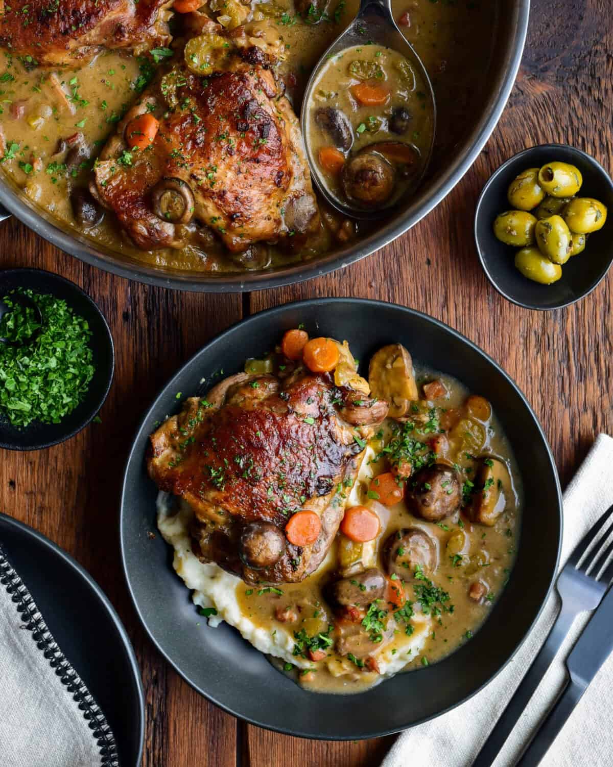 A pan of Turkey Au Vin Rosé and a dish served on a bed of mashed potatoes.