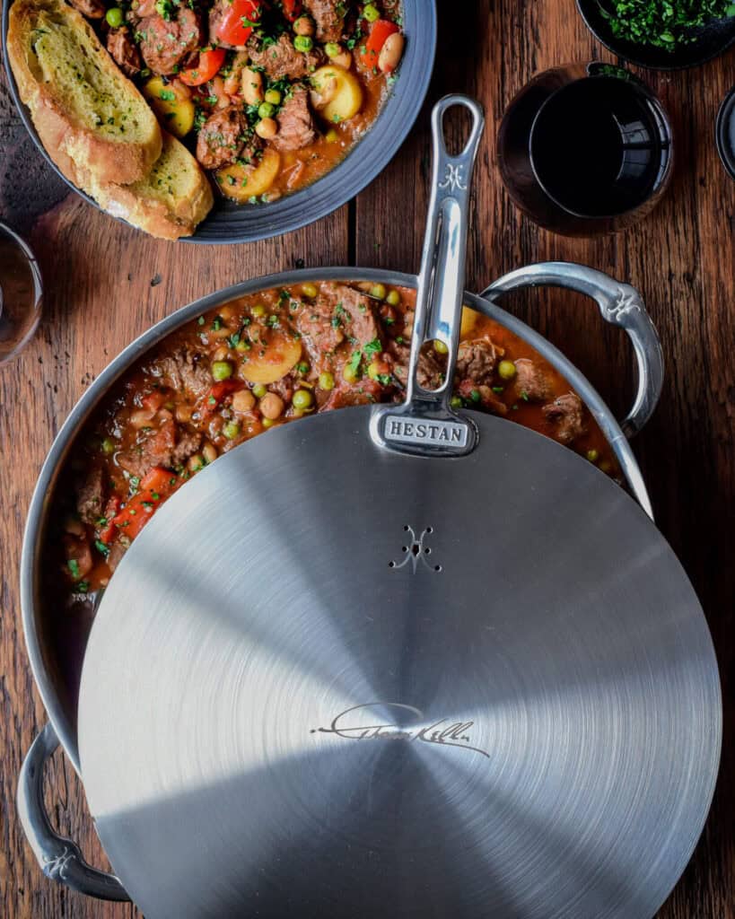 This Spanish lamb stew recipe was made using our Hestan Culinary Thomas Keller 9-QT Rondeau, 12.5” Universal Lid and Chef’s tools.