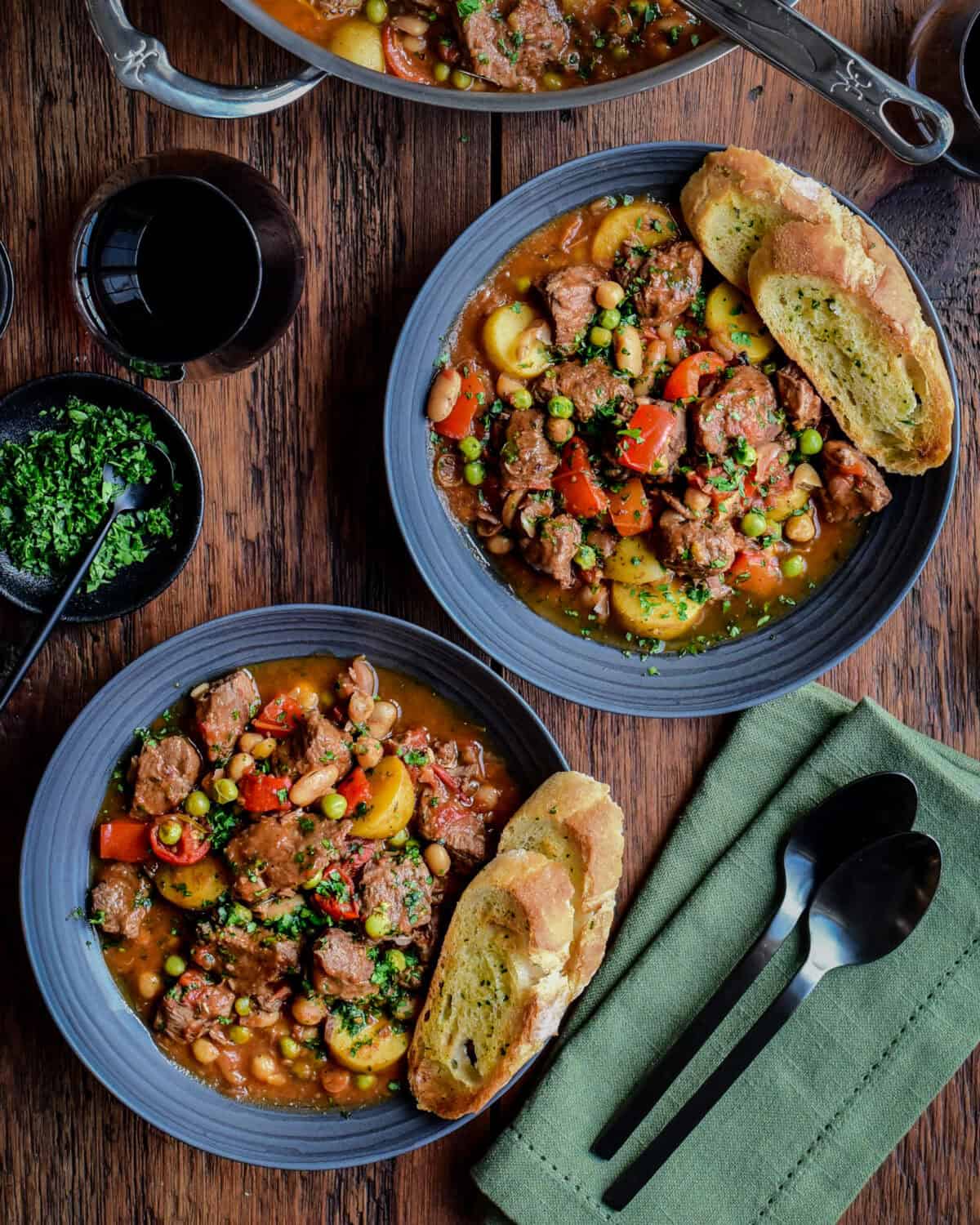 Ladle the Spanish lamb stew into bowls and sprinkle with fresh parsley.