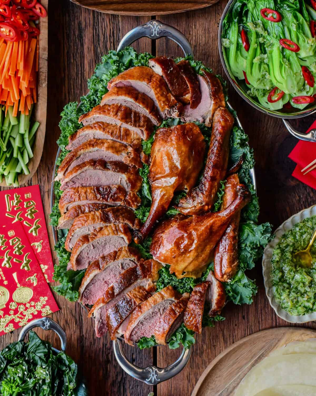 A Lunar New Year spread of a Crispy Roasted Duck - Peking Style with toppings and sides.
