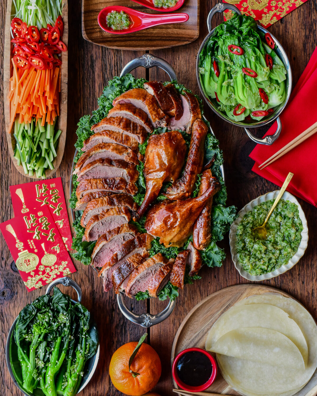 A Lunar New Year spread of a Crispy Roasted Duck - Peking Style with toppings and sides.
