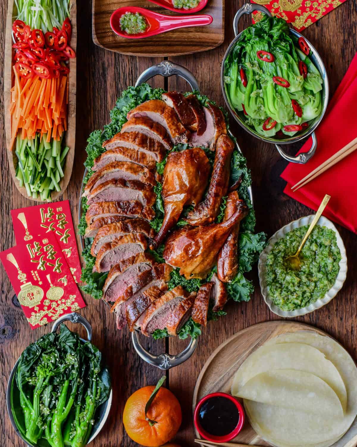 A Lunar New Year spread of a Crispy Roasted Duck - Peking Style with toppings and sides.