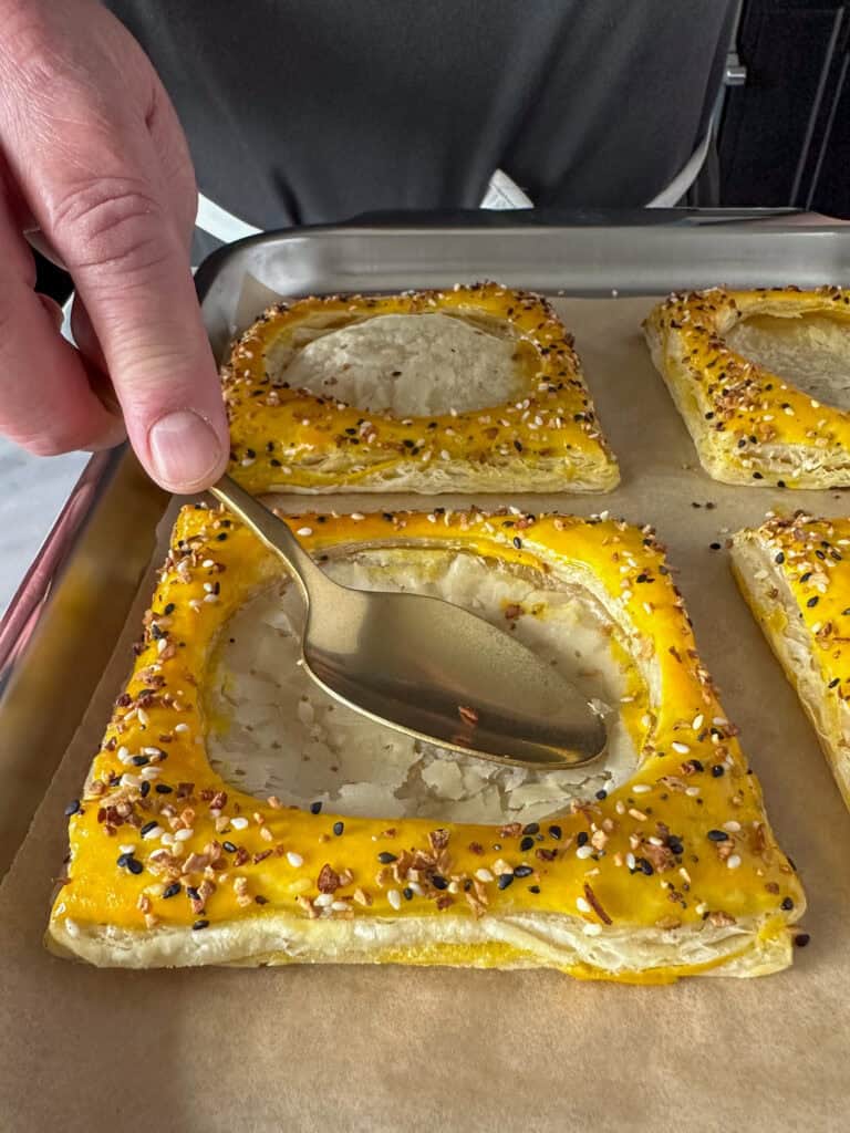 Gently flatten the center of each puff pastry with the back of a spoon.