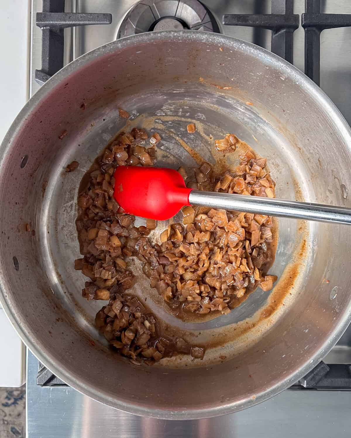 Stir in garlic, a pinch of salt and pepper, hot paprika, sweet paprika, and Aleppo pepper in with the onions.