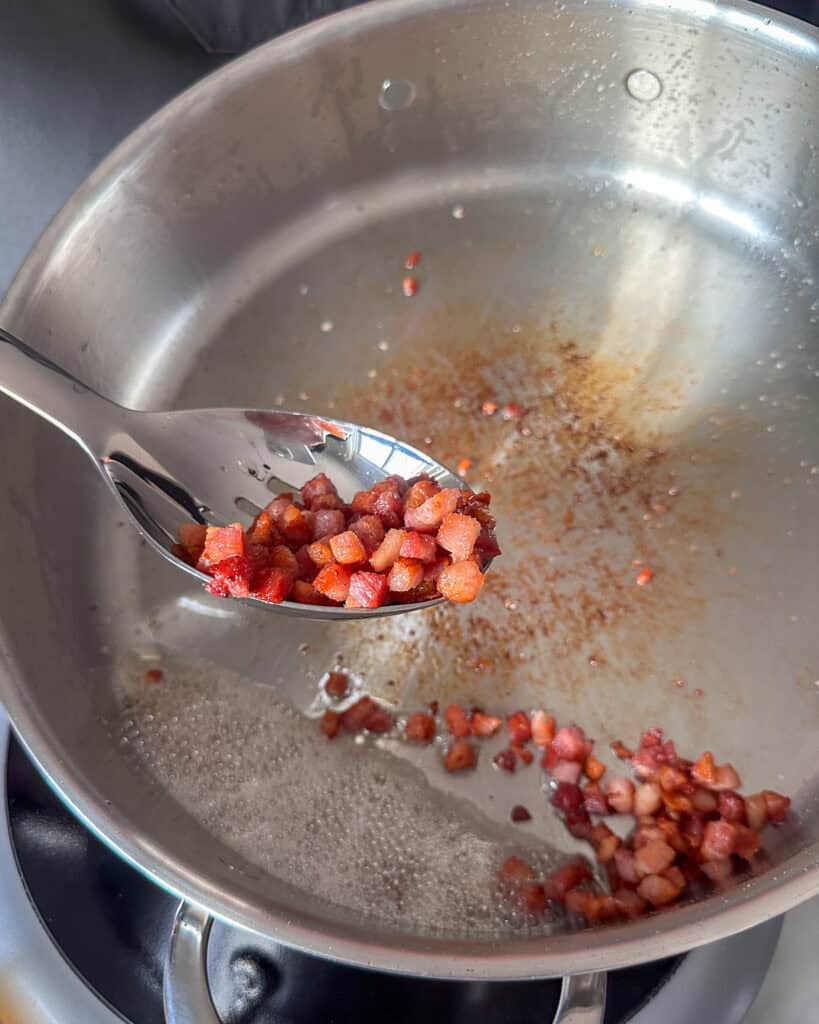 Use a slotted spoon to transfer the cooked pancetta to a paper towel-lined plate.