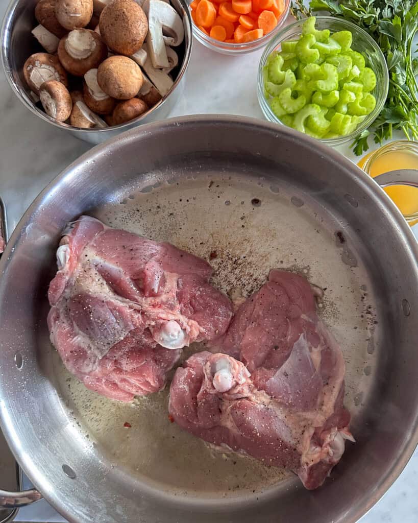 Browning two turkey thighs at a time in a pan, skin side down, for 5 minutes until golden.