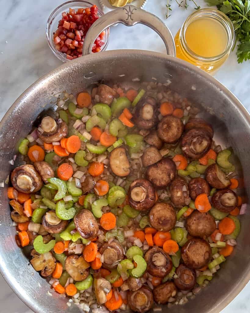 Stir in shallots, celery, carrots, and butter in with the mushrooms.