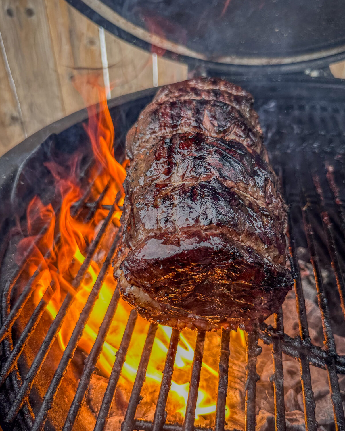 Sear the roast directly over the hot coals for 1-2 minutes per side, rotating often to achieve an even crust and to avoid burning from flare-ups.