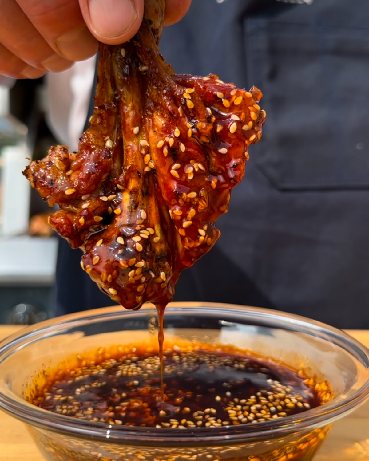 A grilled gochujang butterflied drumstick dipped into the sauce.