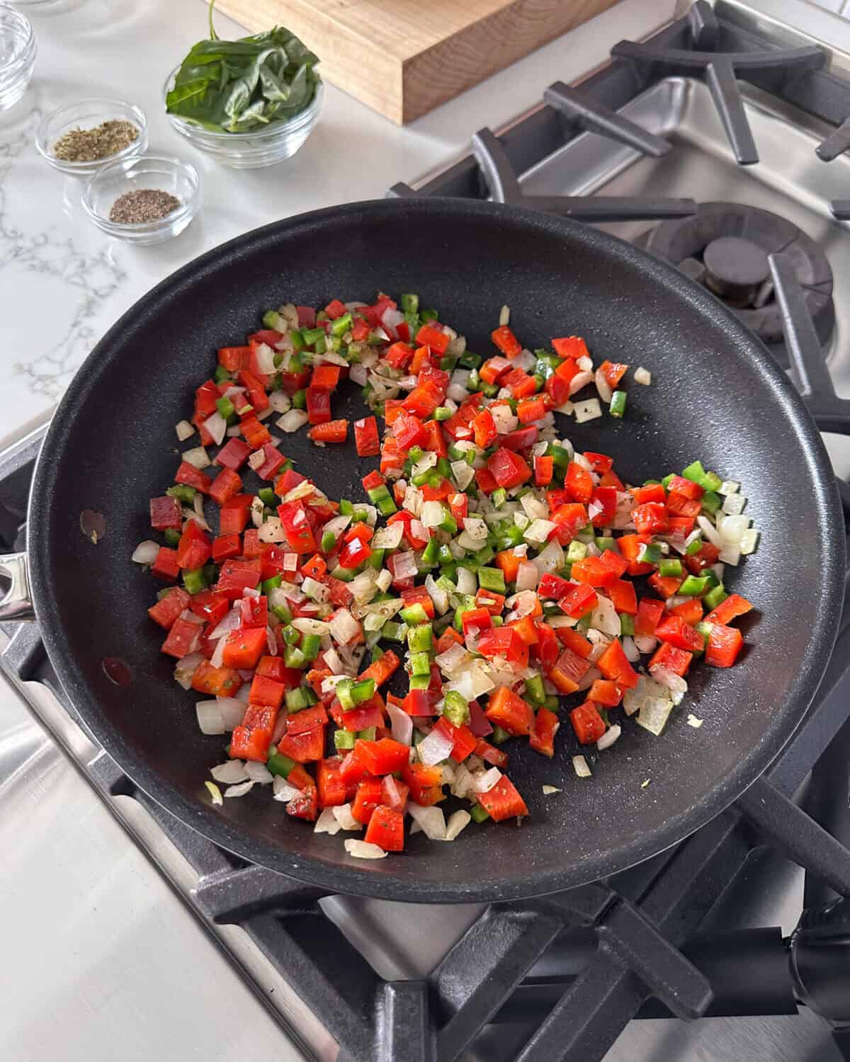 Sautéed onions and peppers in a skillet.