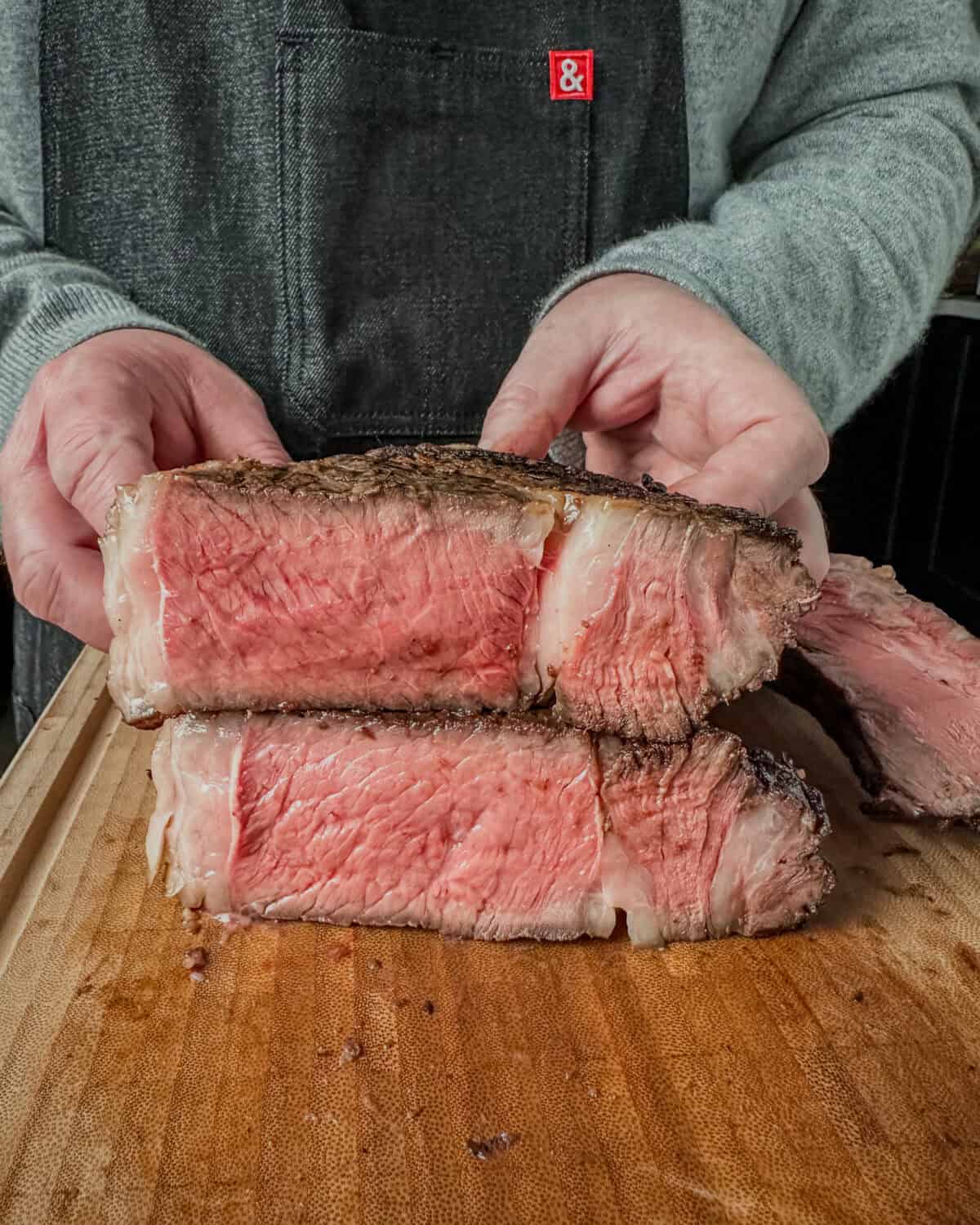 A prime rib sliced in half to reveal the pink interior.