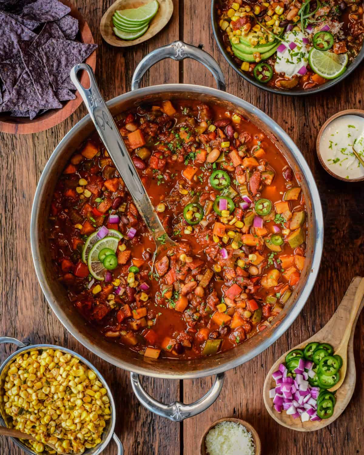 A big pot of chili, served with low sodium tortilla chips for scooping and top it with vibrant, flavourful toppings like Cajun corn, grated cheddar, a dollop of lime-infused sour cream, fresh avocado slices, jalapeños, cilantro and green and red onions.