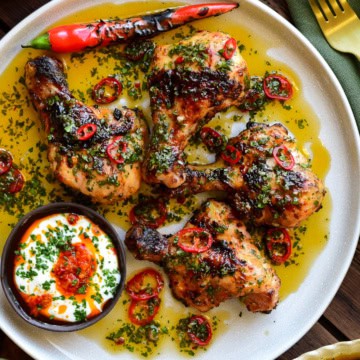 A close up of a plate of Butterflied Chicken Drumsticks with Sweet & Spicy Herb Sauce.