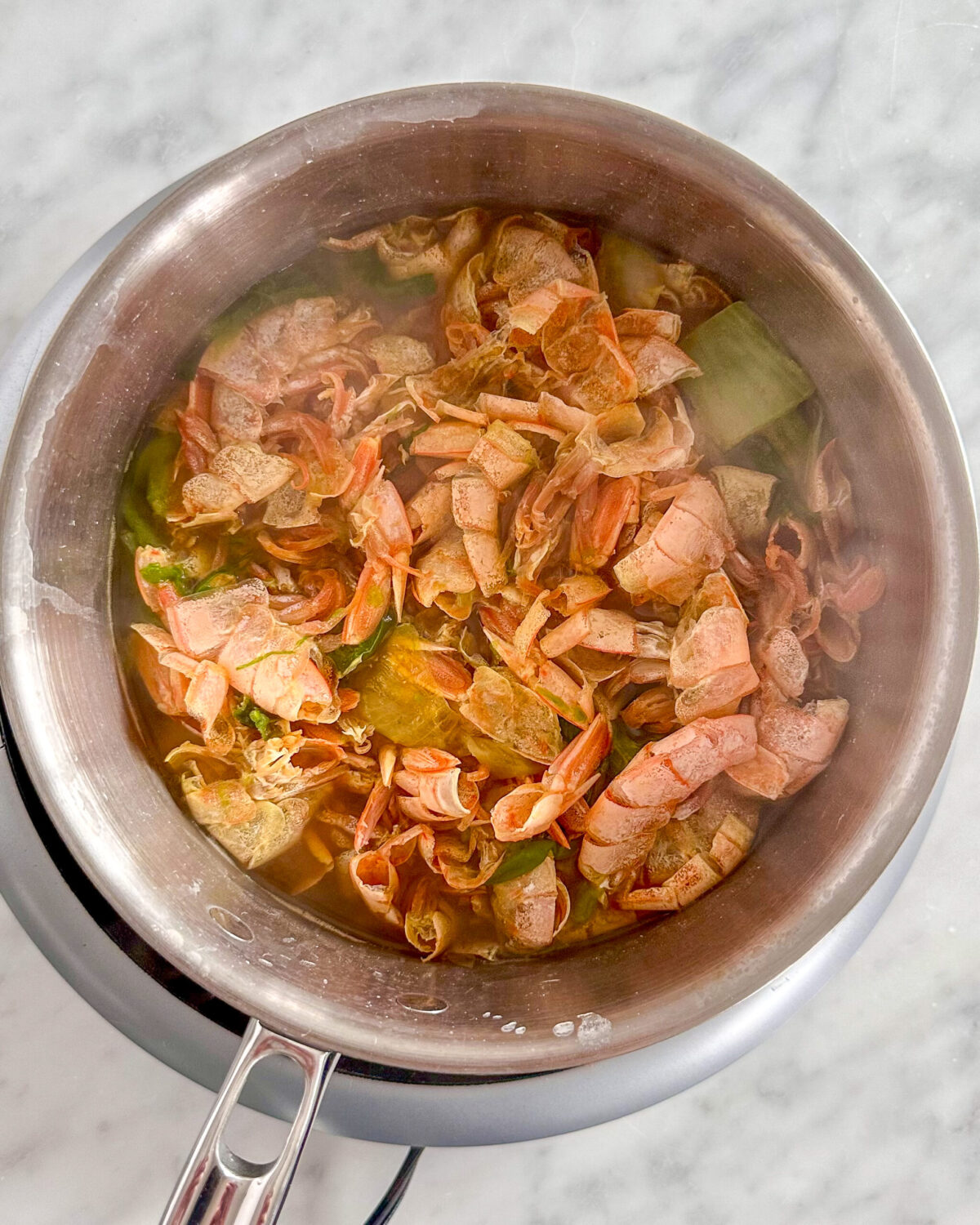 Making shrimp stock with shrimp shells.