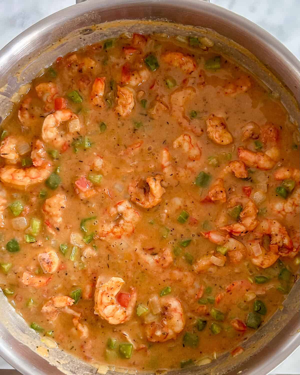 Shrimp added into the pot with sauce.
