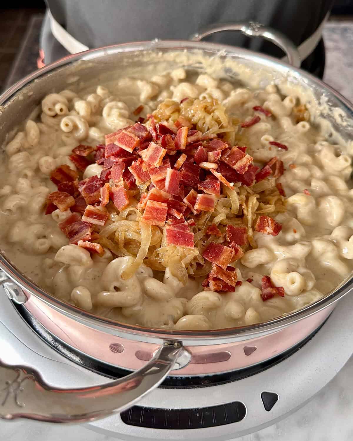 Stir cooked pasta into the cheese sauce. Fold in caramelized onions and crispy bacon.