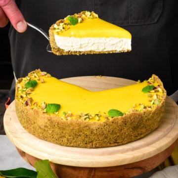 A slice of lemon curd pie with graham cracker crust getting lifted out of the pie.