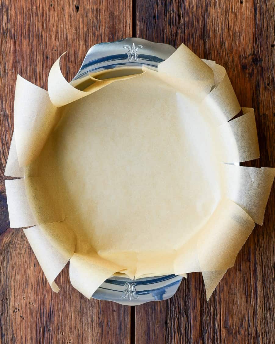 Place the pan upright and tuck the parchment inside, ensuring it lines the bottom and sides for the lemon curd pie.