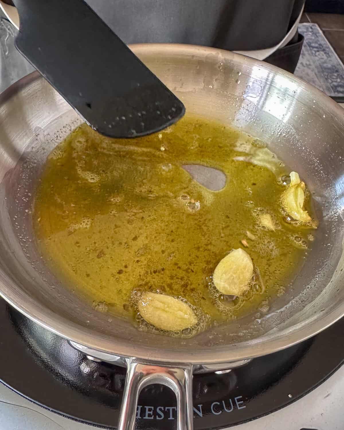 Warm the oil gently in a small pan with garlic.