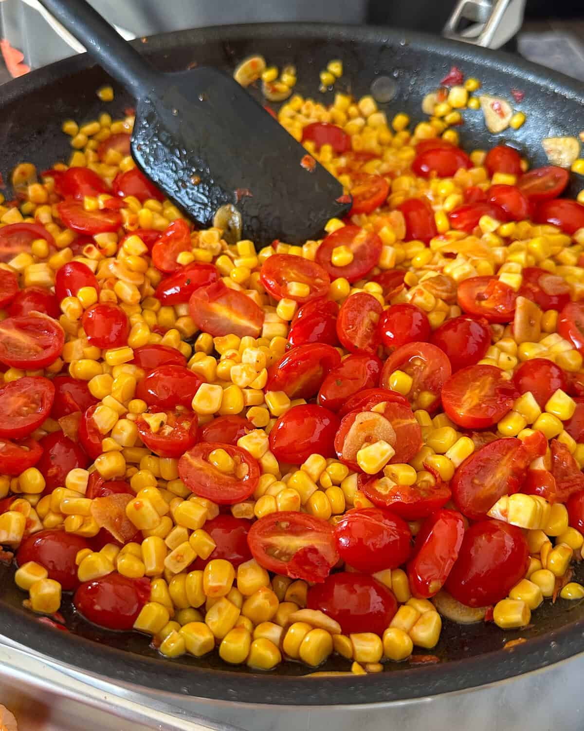 Add the tomatoes and corn to the skillet.