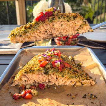A cut-out piece of an herb-crusted salmon with a strawberry salsa.