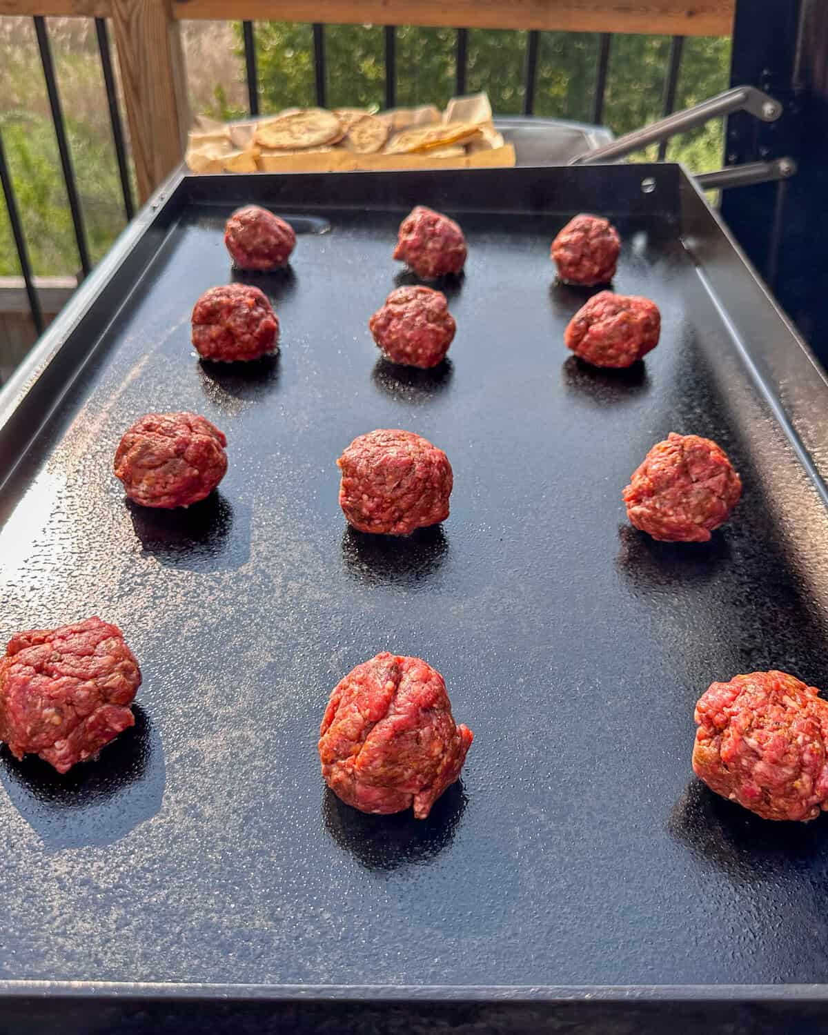Lamb balls are evenly placed on a griddle, about to get smashed.