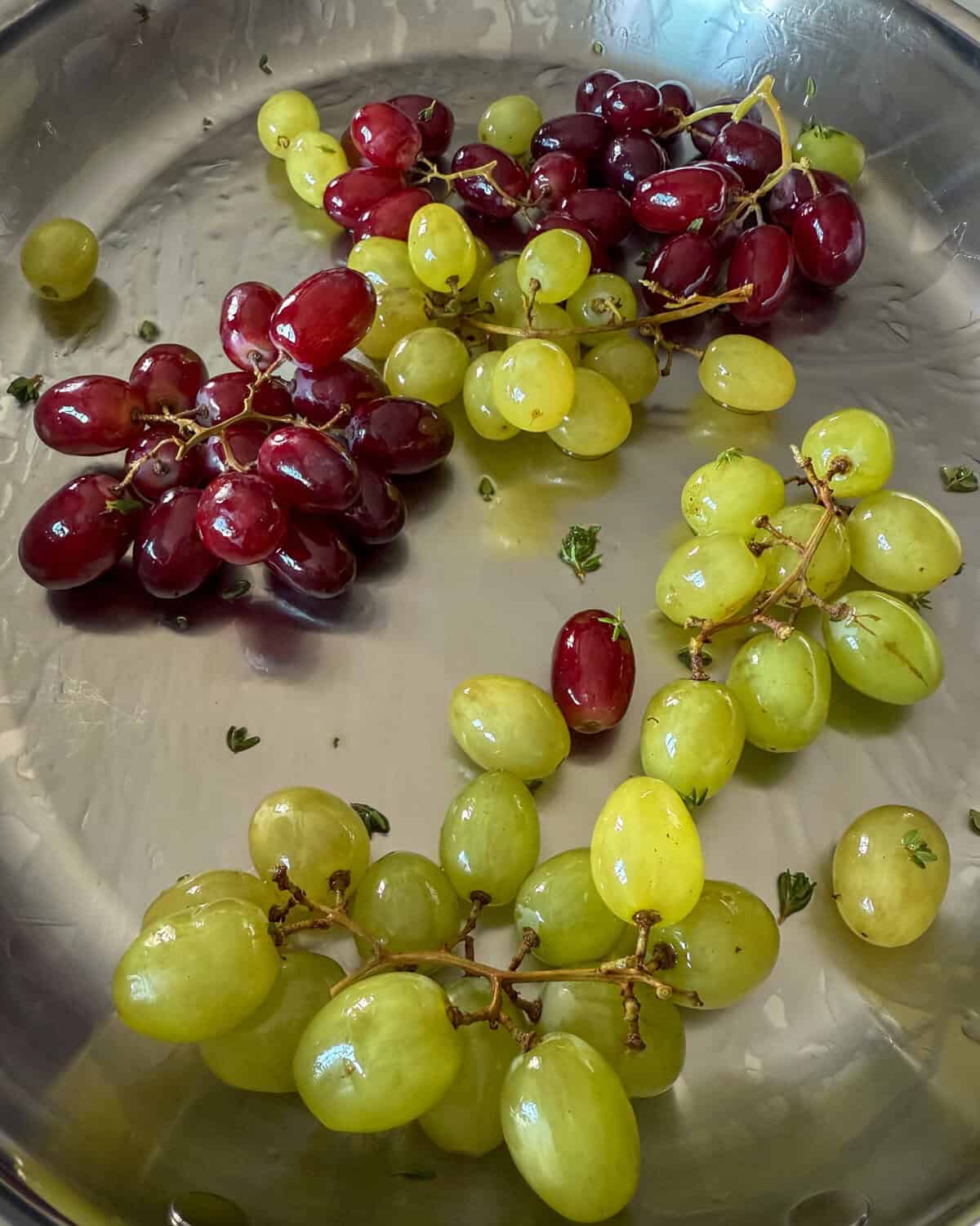 Toss the grapes in oil and thyme for roasting in the oven.