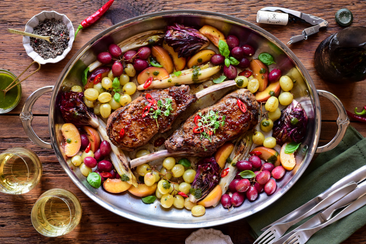 A platter of diavola veal rib chops marinated and cooked in the oven with roasted fruit and veggies.