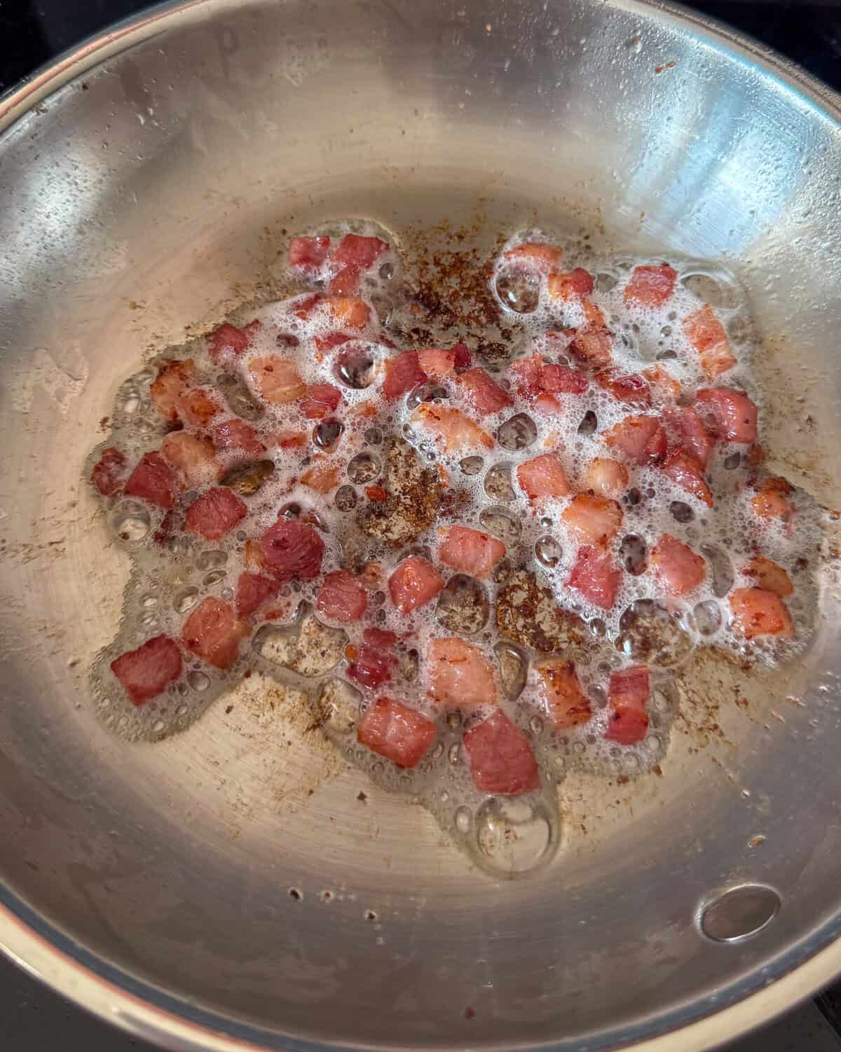Pancetta is getting cooked for scallops in half shell recipe.