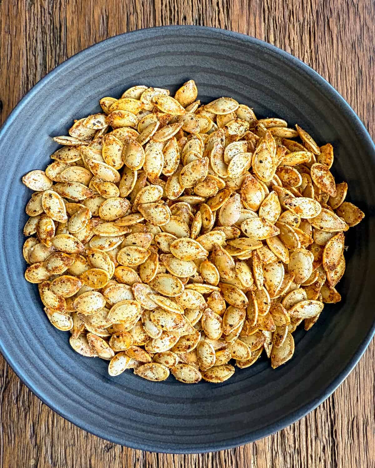 A bowl of Spicy Roasted Pumpkin Seeds with Paprika, Cayenne & Garlic.