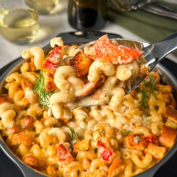 Lifting a scoop of a lobster style mac and cheese.