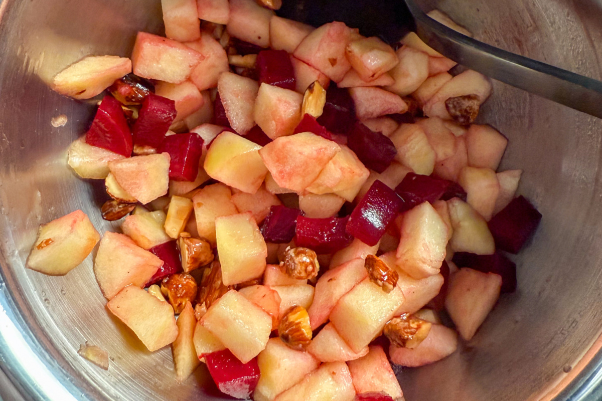 A bowl of the beet, apple and candied nuts mixture.