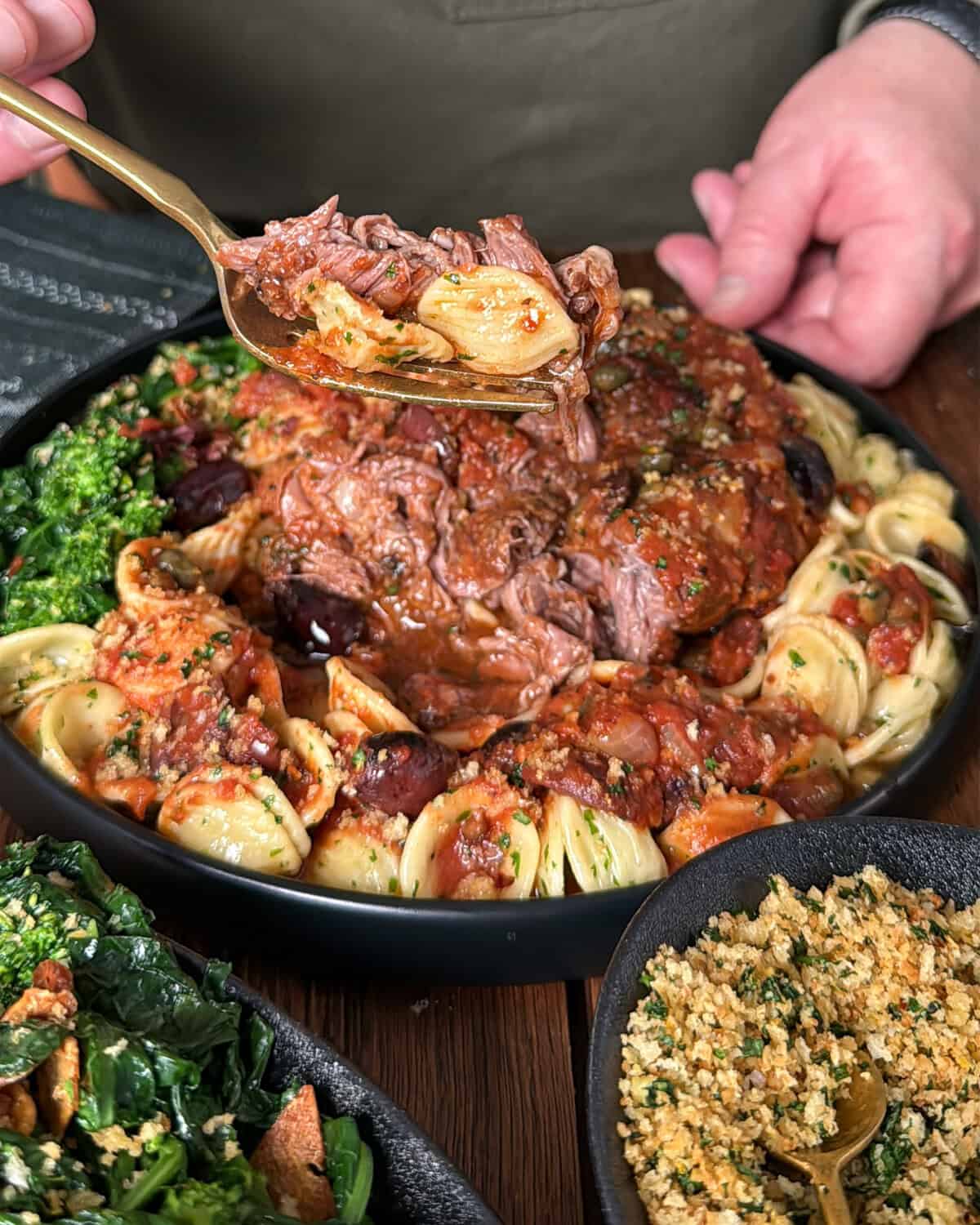 A forkful of braised veal osso buco with Puttanesca sauce.