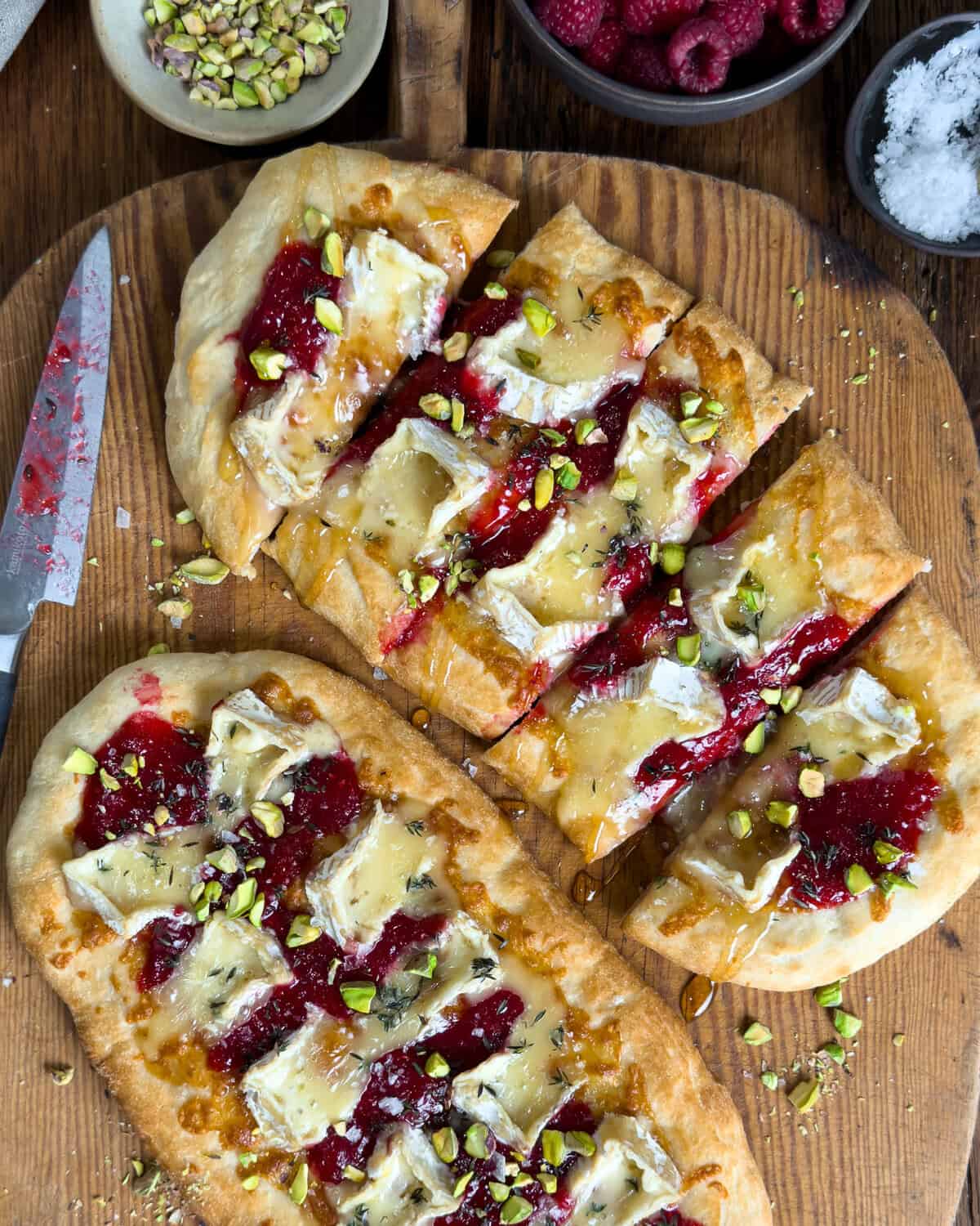 Two Flatbread Appetizers with Camembert & Raspberry Prosecco Jam, one is cut into pieces.