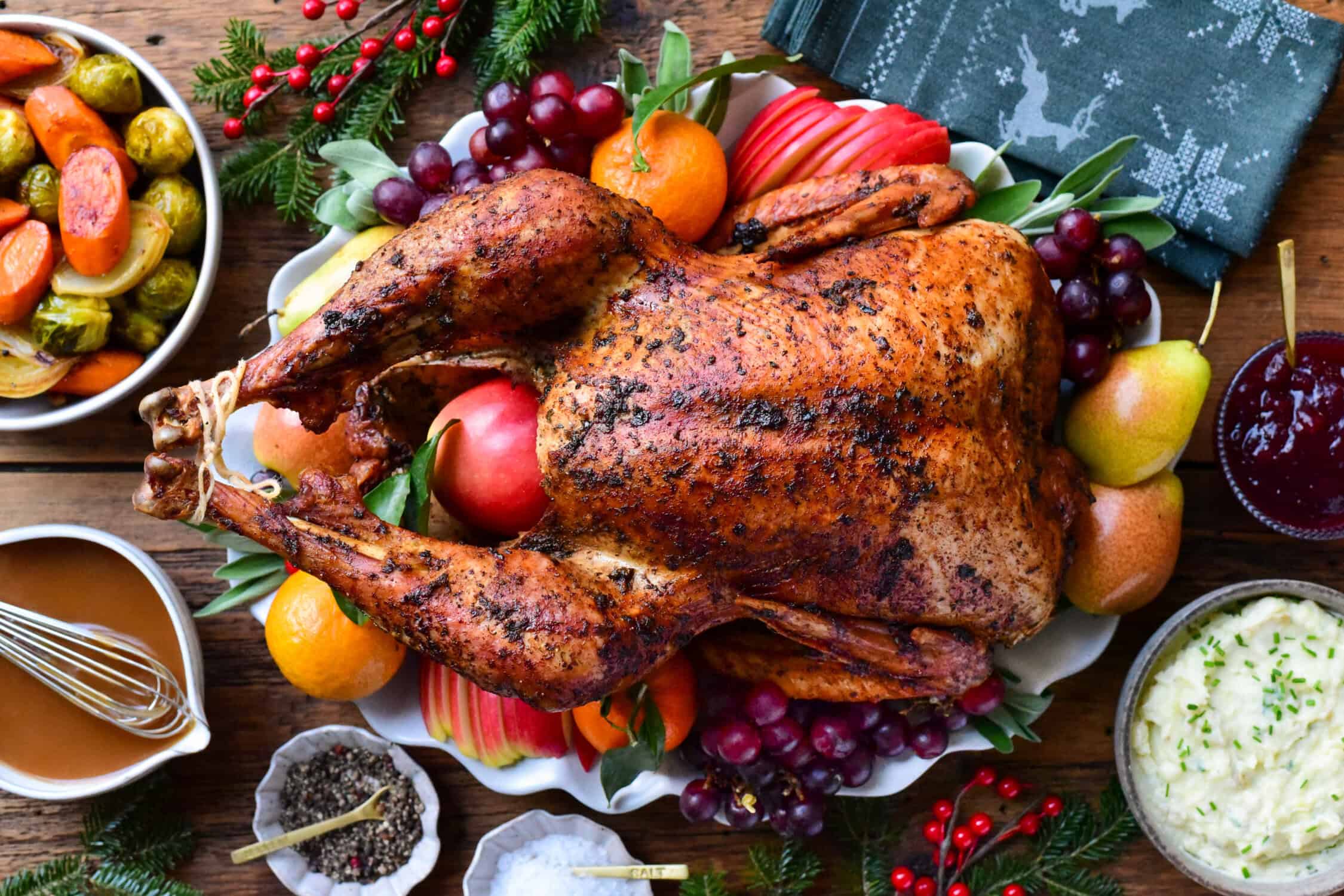 A garlic and herb roasted turkey served with roasted vegetables, mashed potatoes, cranberry sauce, stuffing and homemade gravy for a classic holiday plate.