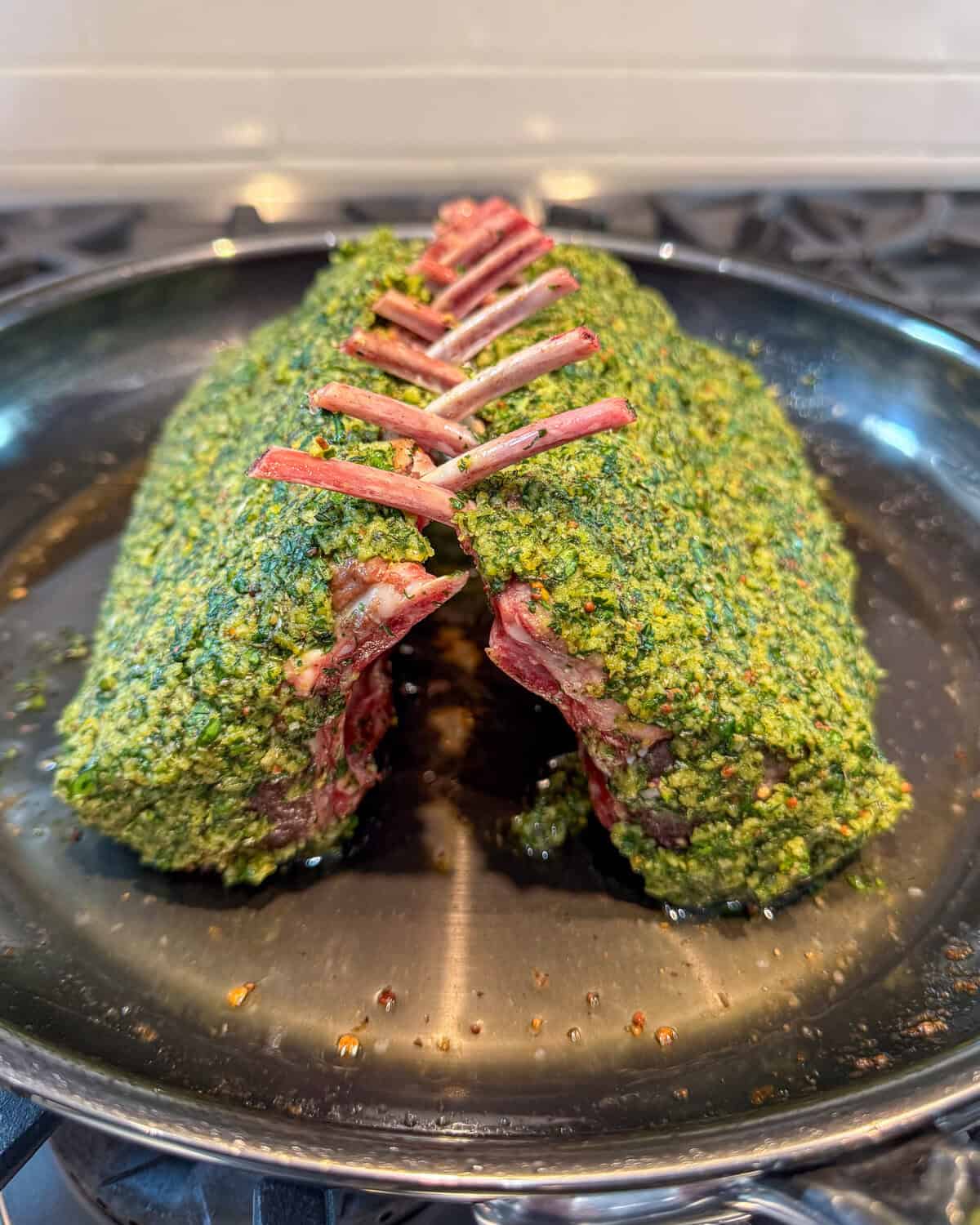Carefully return the racks to the skillet, bone-side up, leaning toward each other, with the bones interlocking slightly at the top, forming a tented, crown-style shape.