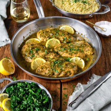 A skillet of lemony chicken picatta is served with orzo and spinach.