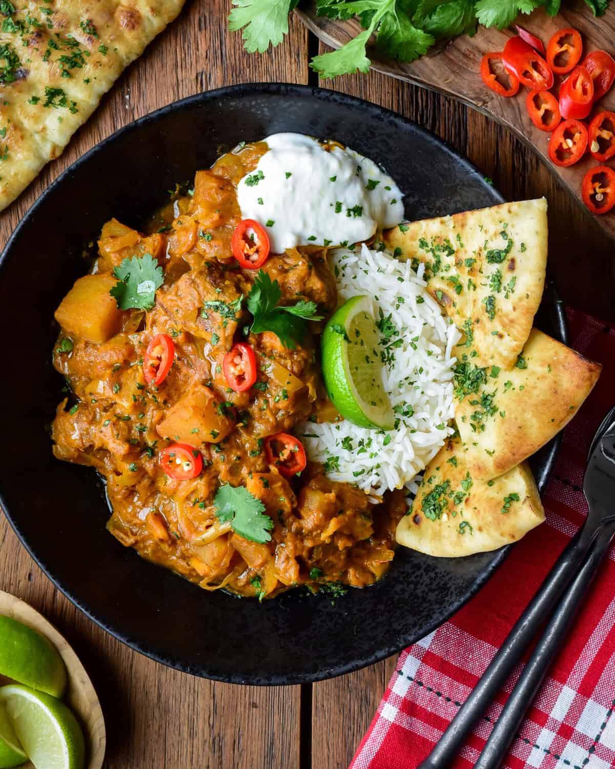 A bowl of beef and vegetable coconut curry served with basmati rice, coconut rice and garlic naan.