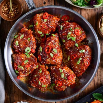 A skillet of crispy maple gochujang fire chicken thighs.