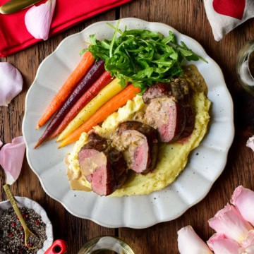 Three medallions of reversed seared veal tenderloin served with a Dijon Cognac sauce, potato puree, carrots and arugula for a Valentine's Day recipe.