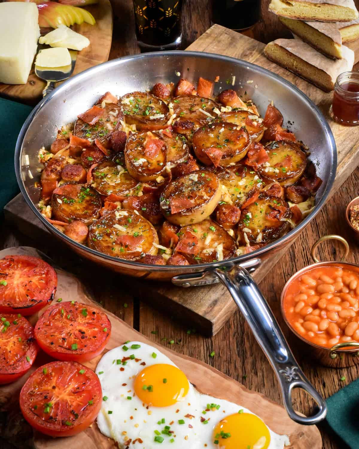 A crispy Irish Pub potato skillet with sausage, bacon and served with sunnyside up eggs, roasted tomatoes and baked beans.