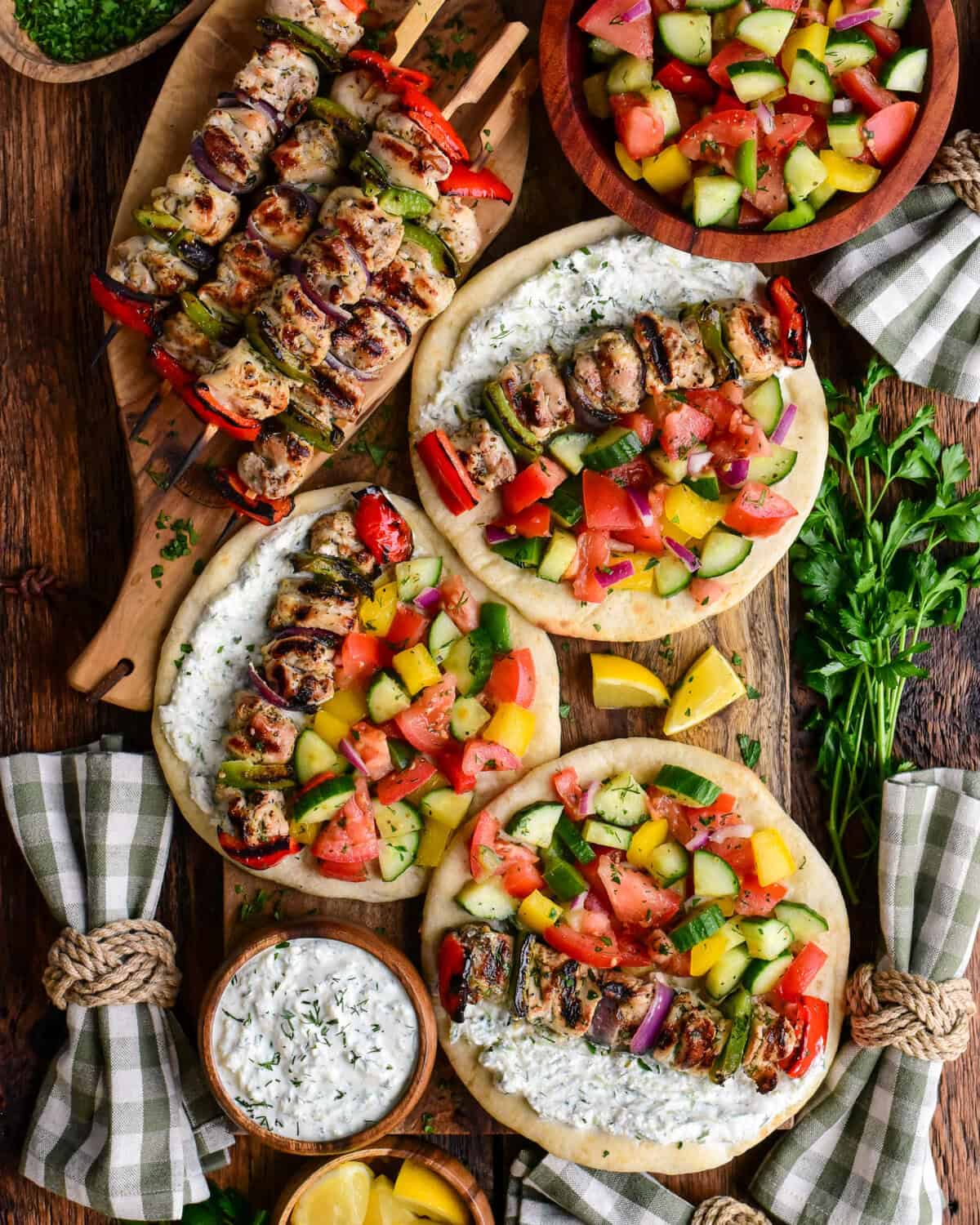 A pile of chicken souvlaki and three pitas loaded with chicken souvlaki, greenhouse salad and whipped feta tzatziki.