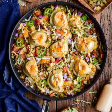 A cheeseburger skillet with pierogi, served with extra toppings on the side.
