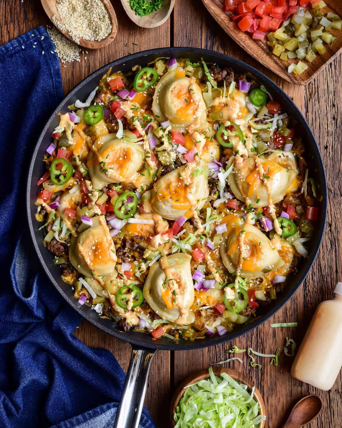 A cheeseburger skillet with pierogi, served with extra toppings on the side.